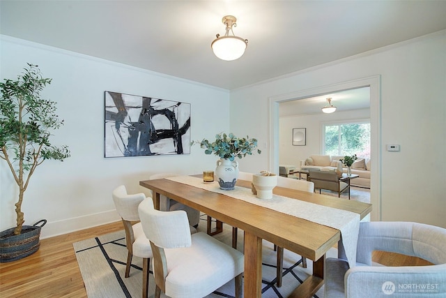 dining area with baseboards and light wood-style flooring