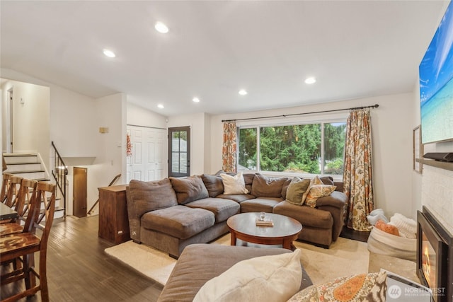 living room with recessed lighting, stairs, wood finished floors, and a glass covered fireplace