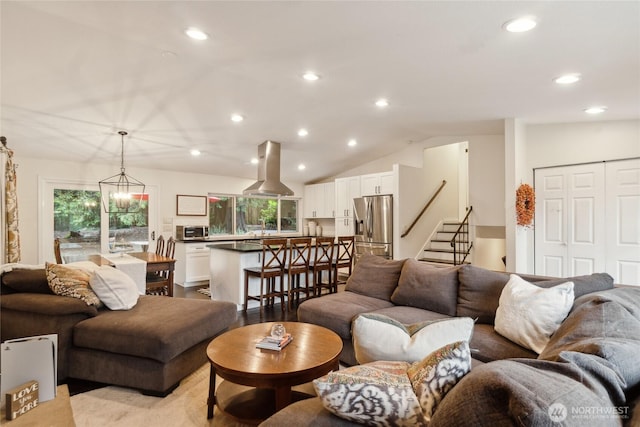 living room with stairs, lofted ceiling, light wood-style flooring, and recessed lighting