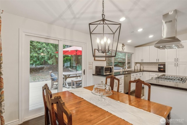 dining area with a chandelier, recessed lighting, and vaulted ceiling