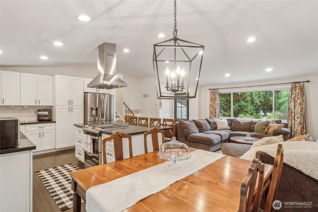 dining space featuring stairway, dark wood-type flooring, vaulted ceiling, a notable chandelier, and recessed lighting