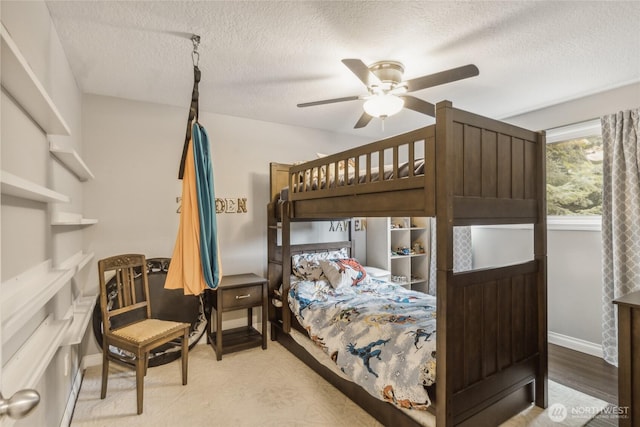 bedroom with a textured ceiling, ceiling fan, and baseboards