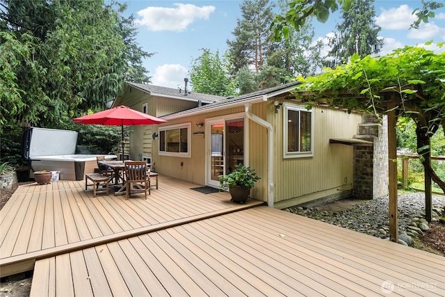 wooden terrace with outdoor dining area and a hot tub