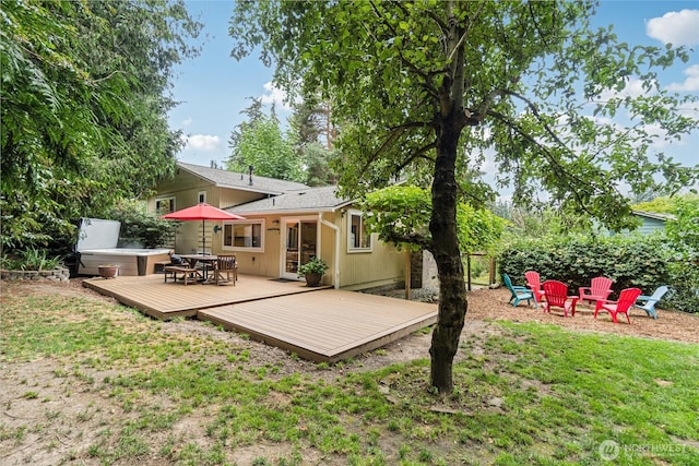 back of house with an outdoor fire pit and a wooden deck