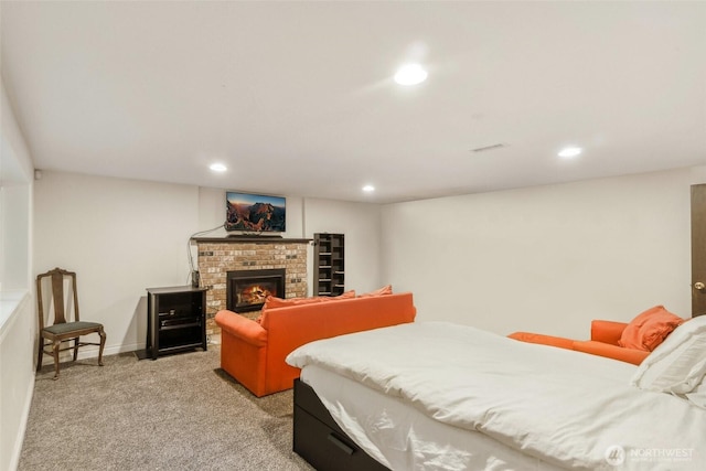 bedroom with visible vents, baseboards, light colored carpet, a fireplace, and recessed lighting