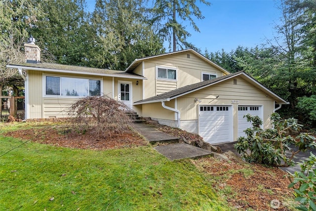 tri-level home featuring driveway, an attached garage, a chimney, and a front lawn