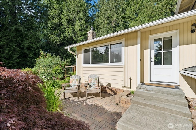 19711 34th Dr SE, Bothell, WA 98012 - view of exterior entry featuring a chimney and a patio area