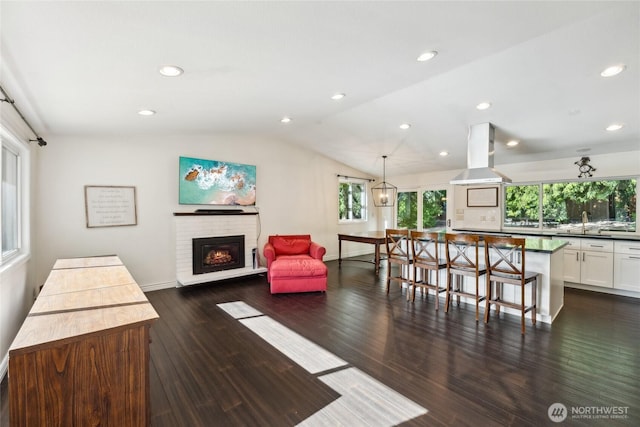 19711 34th Dr SE, Bothell, WA 98012 - living room featuring vaulted ceiling, dark wood finished floors, recessed lighting, a brick fireplace, and baseboards