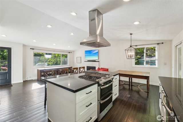 19711 34th Dr SE, Bothell, WA 98012 - kitchen with island exhaust hood, double oven range, white cabinetry, a lit fireplace, and plenty of natural light