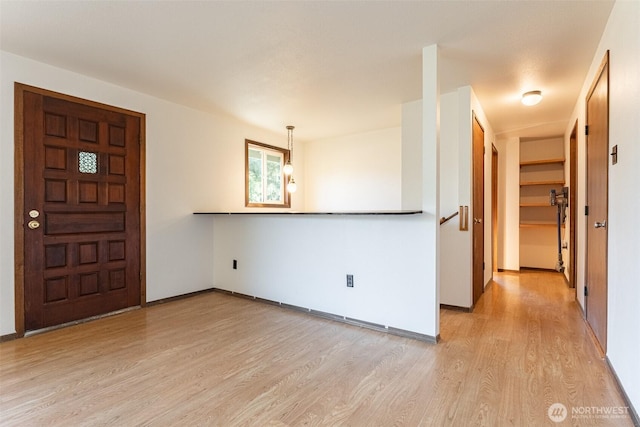 foyer entrance with light wood-type flooring and baseboards