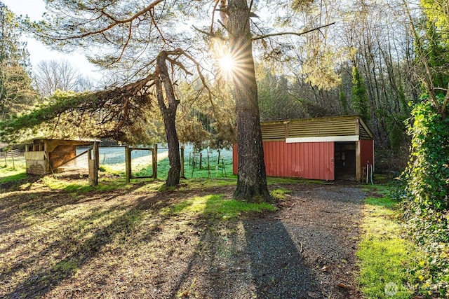 view of yard featuring fence and an outbuilding