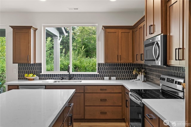 kitchen featuring stainless steel appliances, a healthy amount of sunlight, visible vents, and a sink