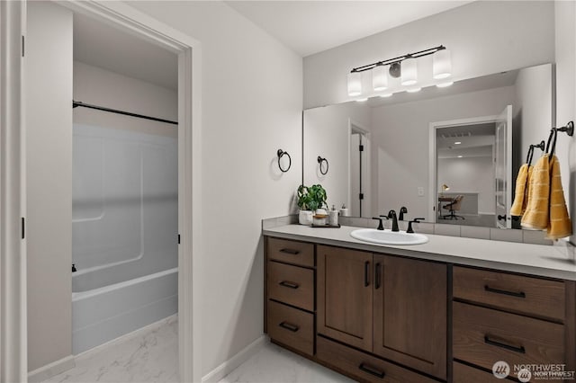 bathroom featuring marble finish floor, vanity, baseboards, and shower / bathtub combination