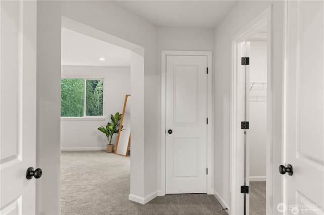 hallway featuring carpet floors and baseboards