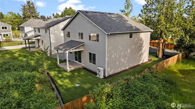 back of house with a patio area, fence, a lawn, and roof with shingles