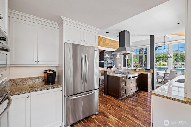 kitchen with stainless steel appliances, island range hood, decorative light fixtures, and white cabinets