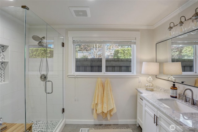 bathroom featuring a stall shower, baseboards, visible vents, ornamental molding, and vanity