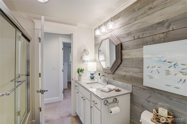 full bath with toilet, a shower with shower door, wood walls, vanity, and ornamental molding