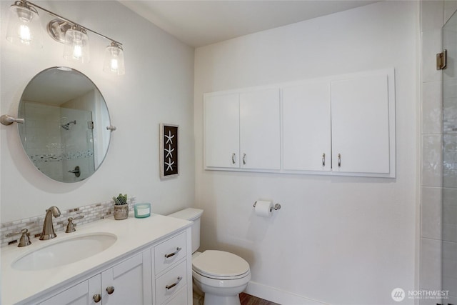 full bath featuring decorative backsplash, tiled shower, vanity, and toilet