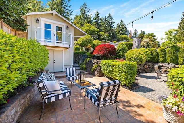 view of patio / terrace featuring an outdoor living space, fence, and a balcony