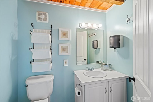 half bathroom with wooden ceiling, vanity, and toilet