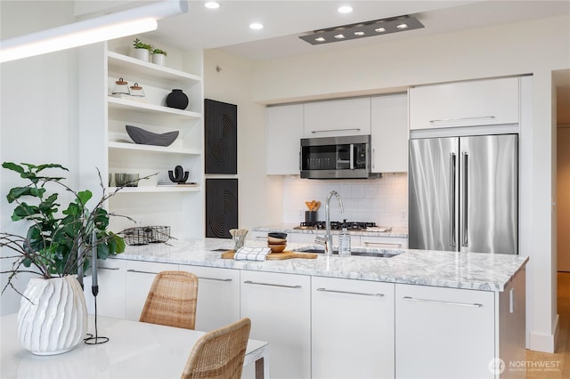 kitchen with stainless steel appliances, white cabinets, open shelves, tasteful backsplash, and modern cabinets