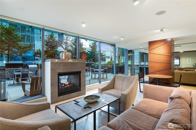 living room featuring tile patterned flooring, expansive windows, and a multi sided fireplace