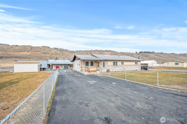 view of front of property featuring a fenced front yard, a mountain view, and a front lawn