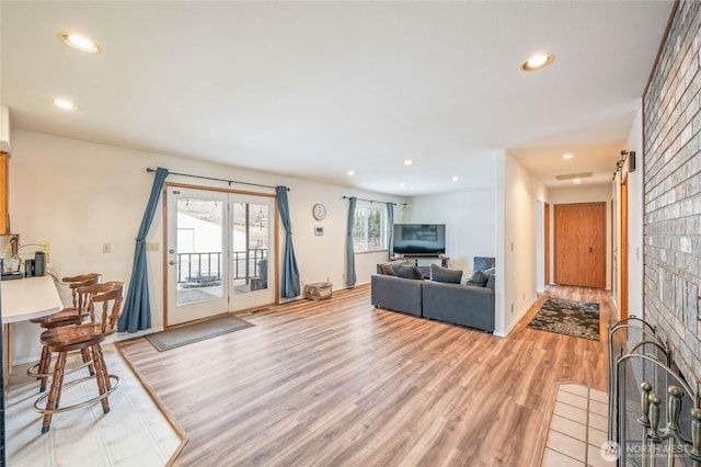 living area featuring light wood finished floors, a barn door, and recessed lighting