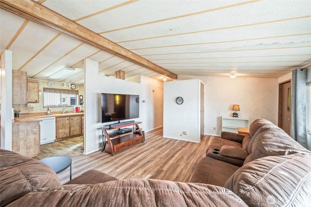 living area featuring lofted ceiling with beams and light wood finished floors