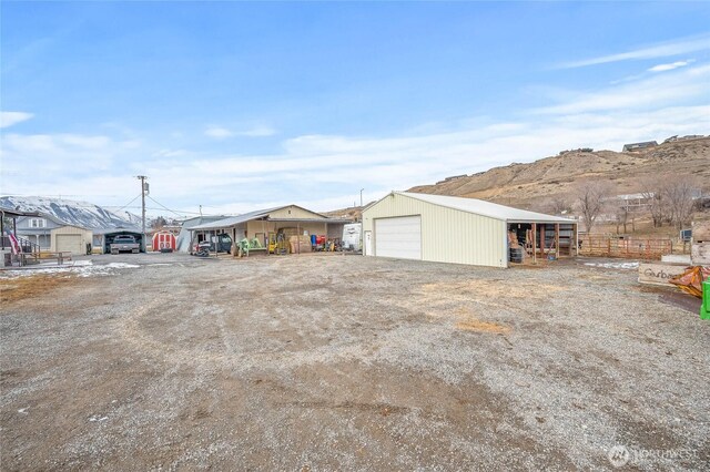 view of yard featuring an outbuilding, a pole building, a mountain view, and a detached garage