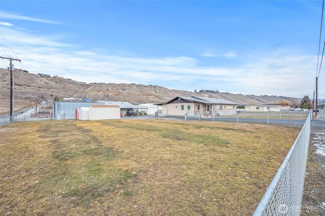 view of yard with a residential view, fence, and a mountain view