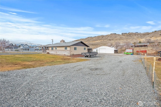 exterior space with a front yard, a mountain view, fence, a garage, and an outdoor structure