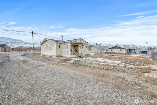 view of front of house with driveway, fence, and a mountain view