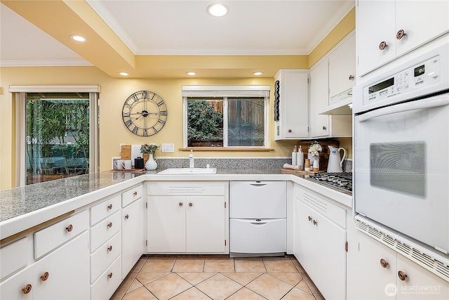 kitchen featuring oven, ornamental molding, a sink, tile countertops, and stainless steel gas stovetop