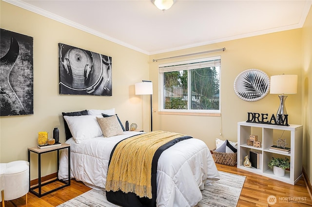 bedroom with wood finished floors, baseboards, and ornamental molding