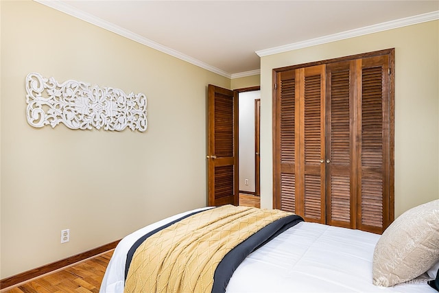 bedroom with a closet, light wood-style flooring, crown molding, and baseboards