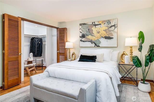 bedroom featuring a closet, a spacious closet, and wood finished floors