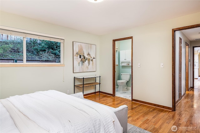 bedroom featuring connected bathroom, baseboards, and wood finished floors