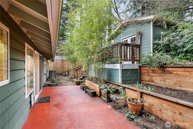 view of patio featuring central AC unit and fence