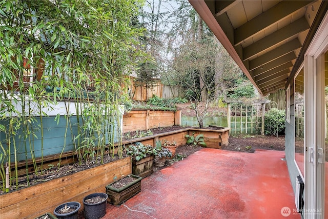 view of patio / terrace with a vegetable garden and fence