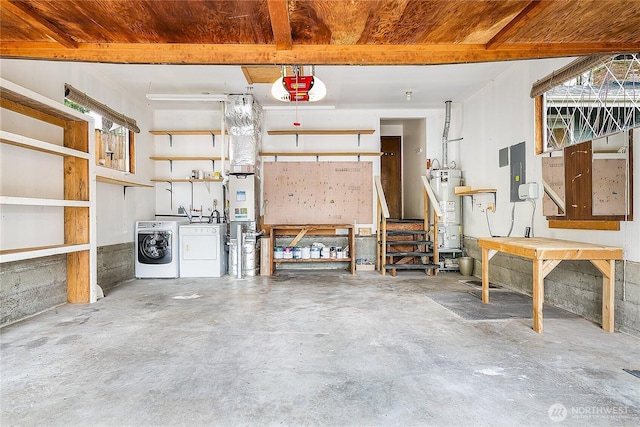 garage featuring electric panel, water heater, a workshop area, a garage door opener, and washer and clothes dryer