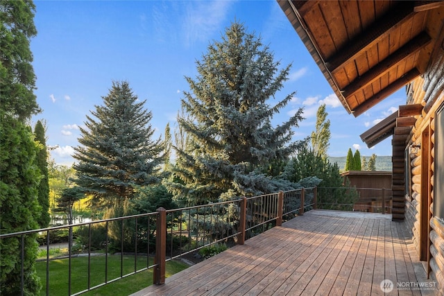 wooden terrace featuring a lawn