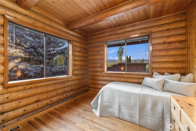 bedroom featuring beamed ceiling, light wood-type flooring, and wooden ceiling