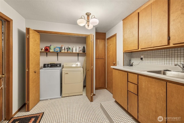 washroom with a sink, laundry area, washer and dryer, and an inviting chandelier