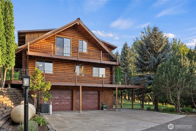 exterior space with concrete driveway, an attached garage, and cooling unit