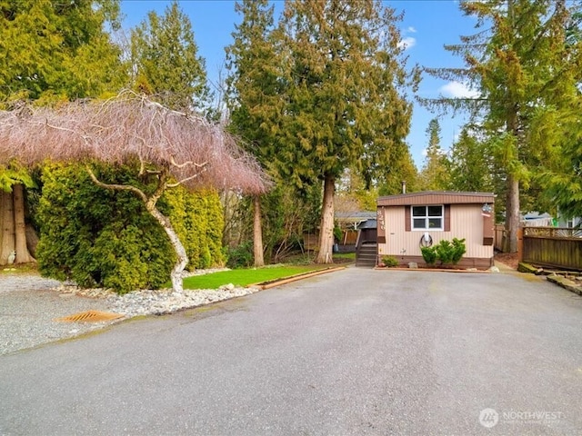 single story home with an outbuilding and fence