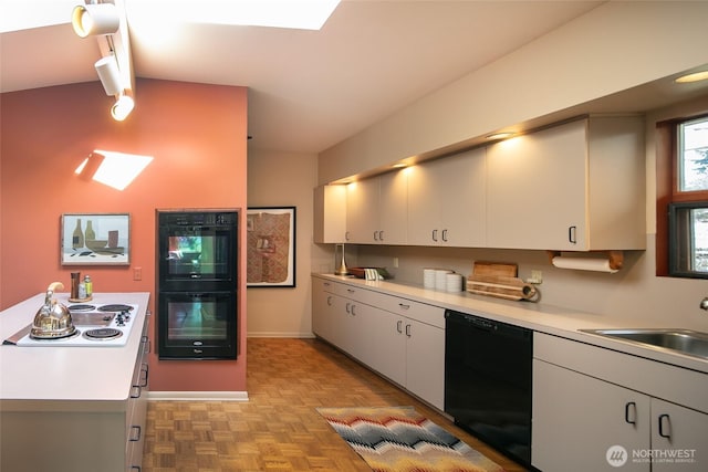 kitchen with black appliances, a sink, light countertops, and white cabinets