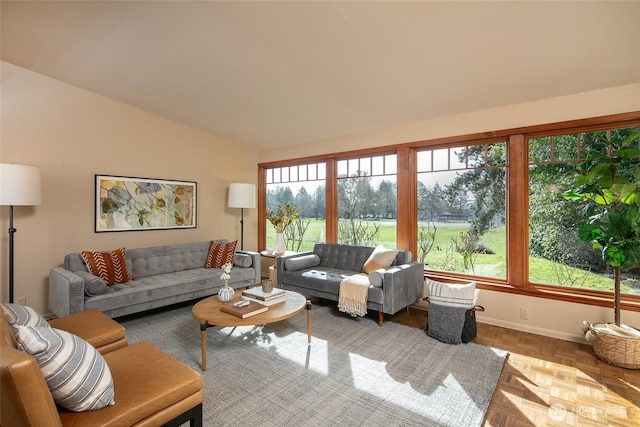 living room featuring lofted ceiling and baseboards