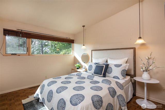 bedroom featuring lofted ceiling and baseboards